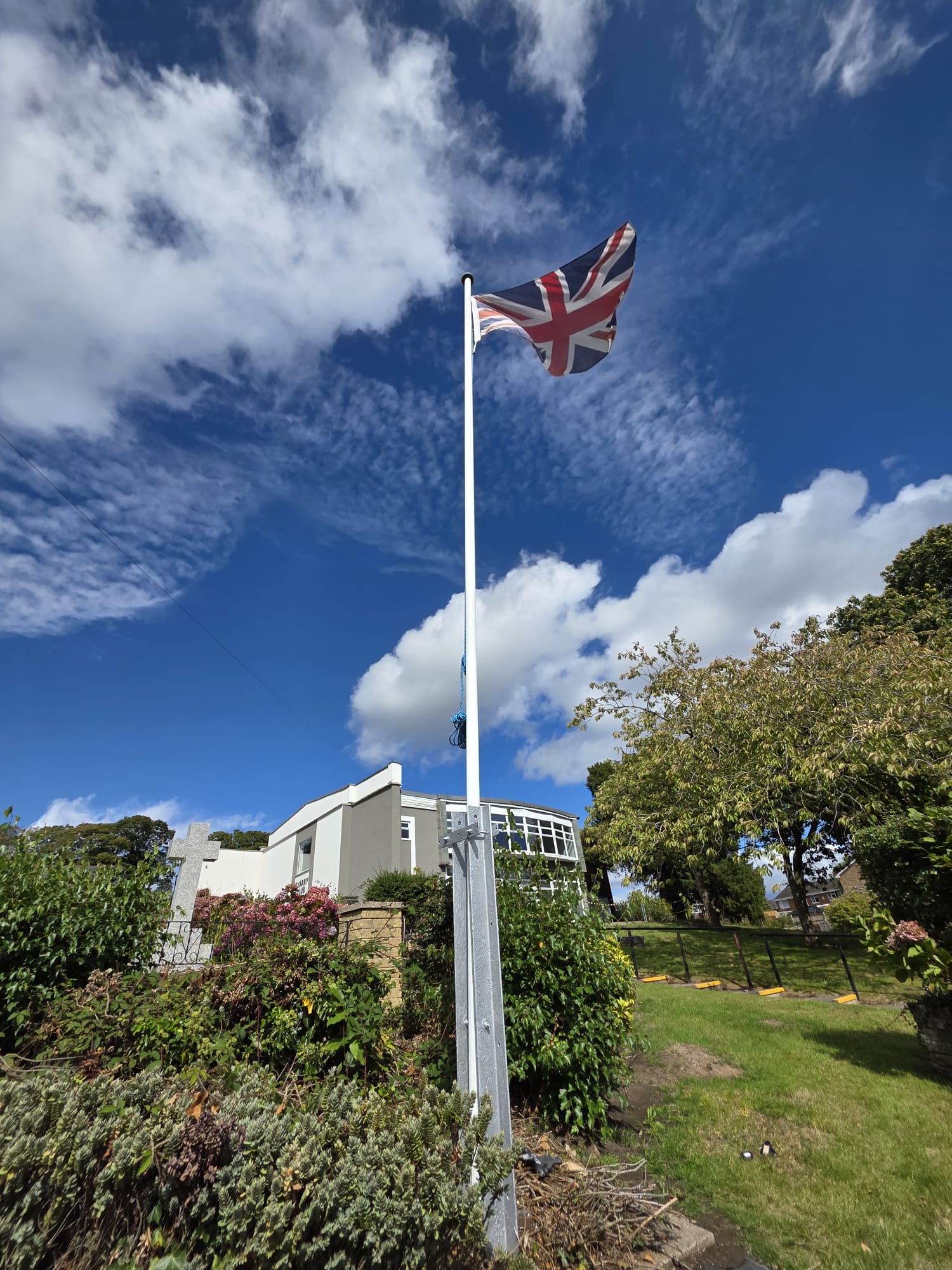 Union flag above the Quarry Club and gardens beneath a blue sky